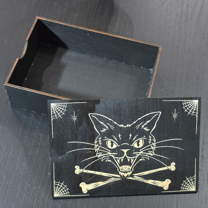 Black box with cat and bones engraved on a dark surface